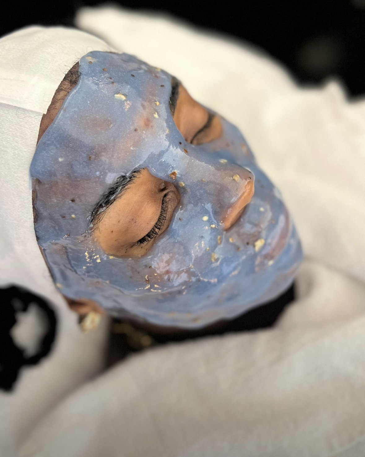 Esthetician performing a lymphatic massage facial on a client at Shine