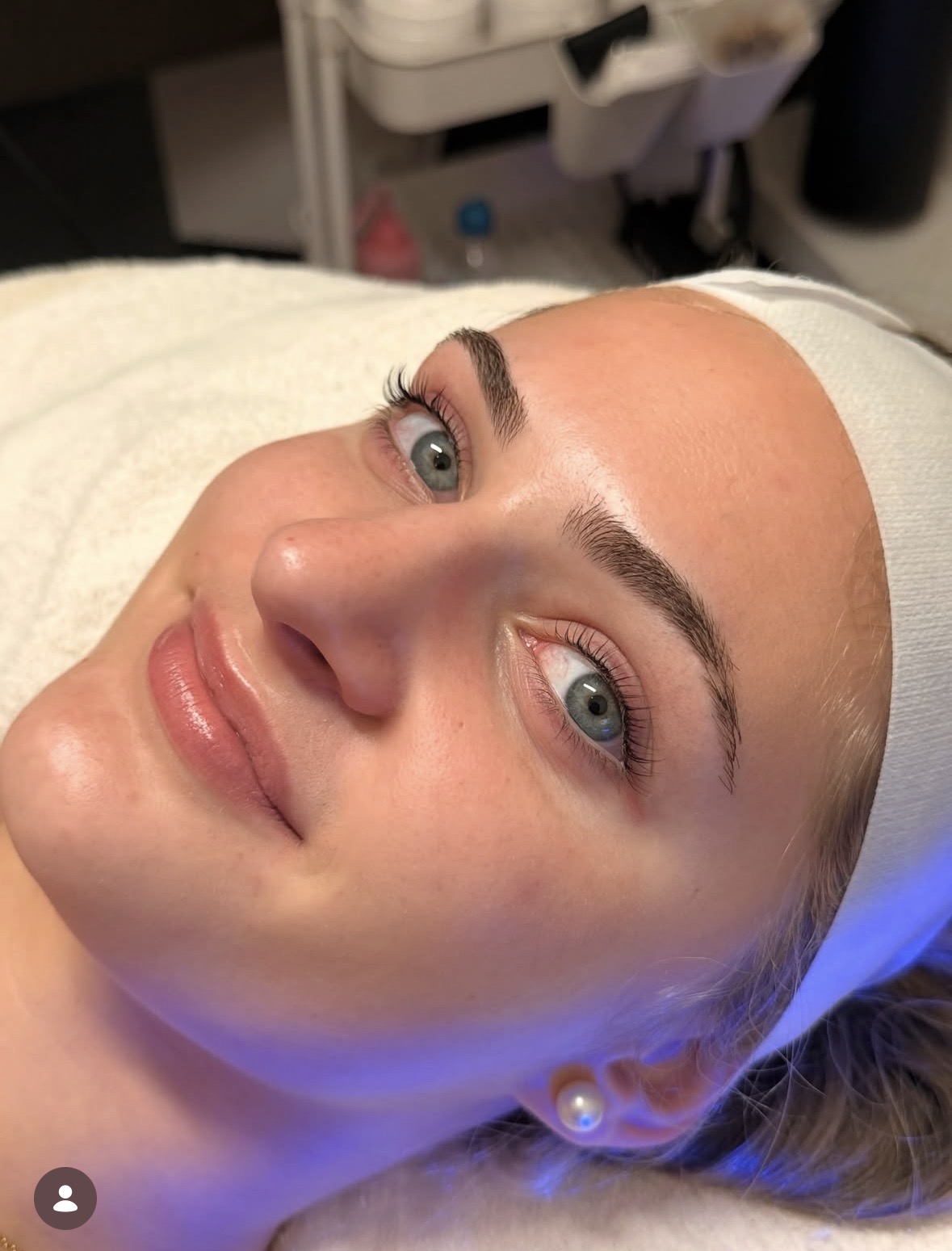 A Shine client relaxing under blue LED light after a facial